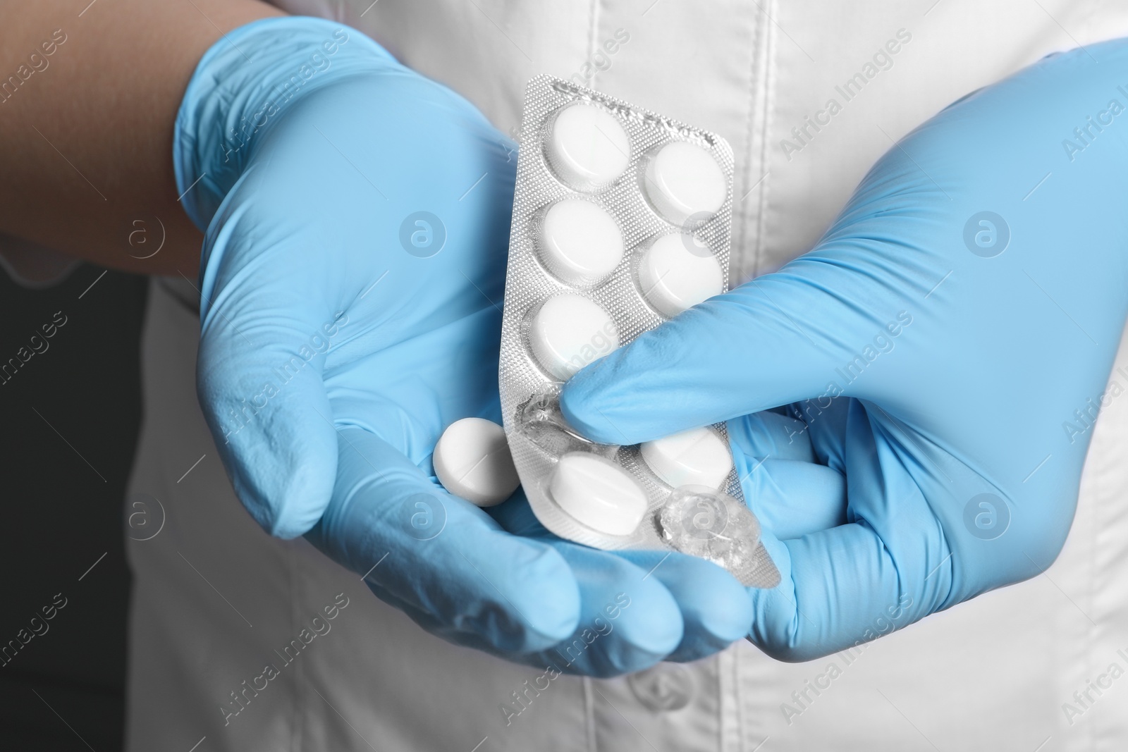 Photo of Doctor taking pill out from blister pack, closeup