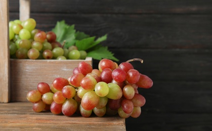 Photo of Fresh ripe juicy grapes on table against blurred background with space for text