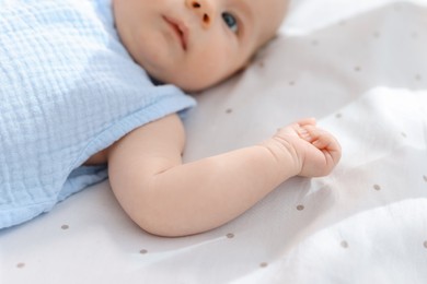 Photo of Cute little baby lying in crib at home, selective focus