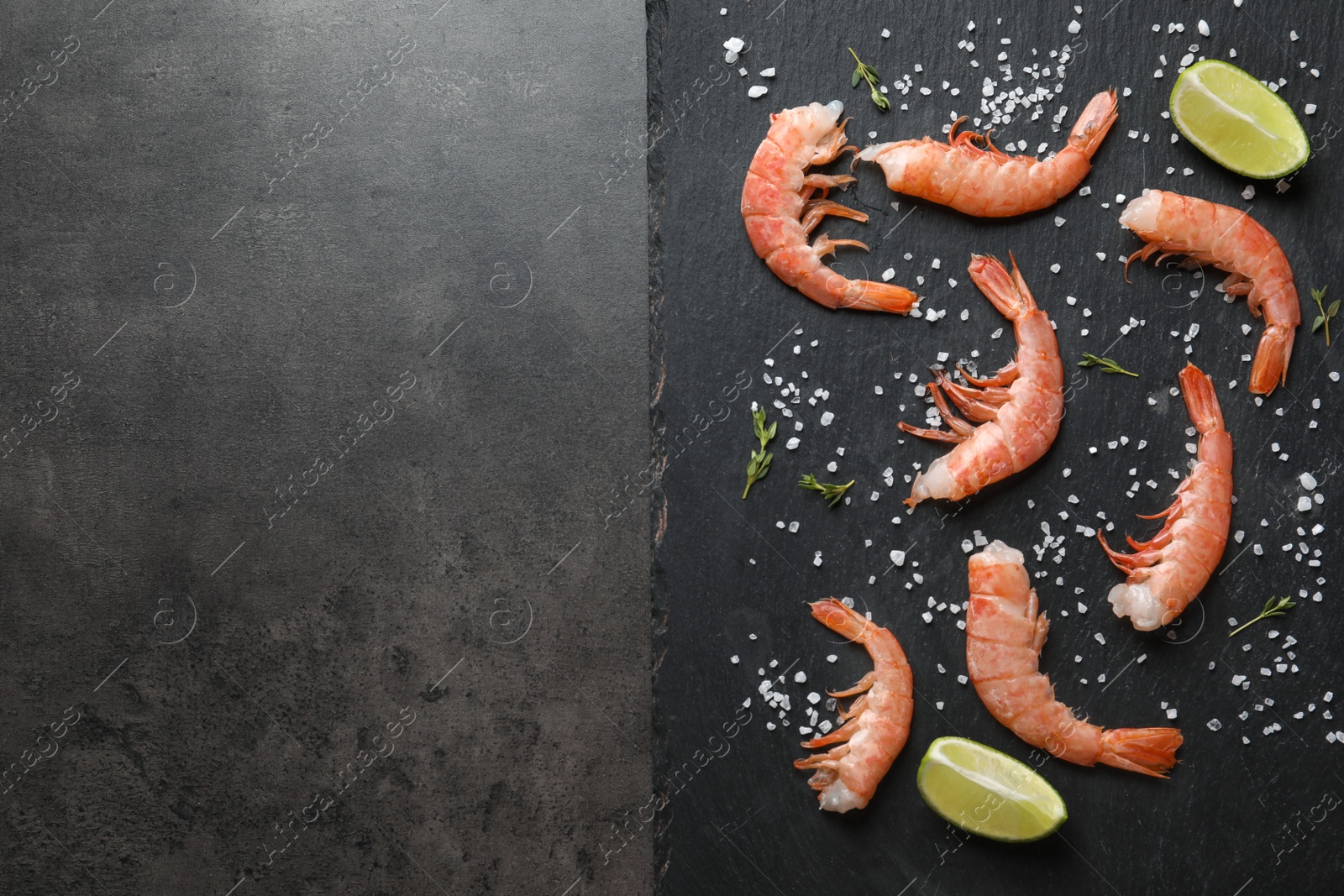 Photo of Fresh shrimps with lime and salt on slate plate