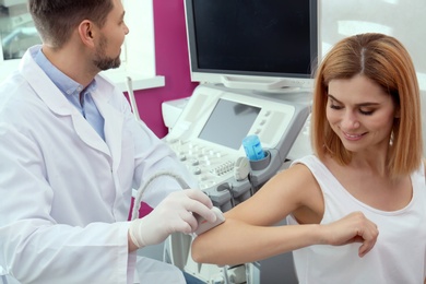 Doctor conducting ultrasound examination of elbow joint in clinic