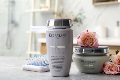 Photo of MYKOLAIV, UKRAINE - SEPTEMBER 07, 2021: Kerastase hair care cosmetic products and brush on light table in bathroom