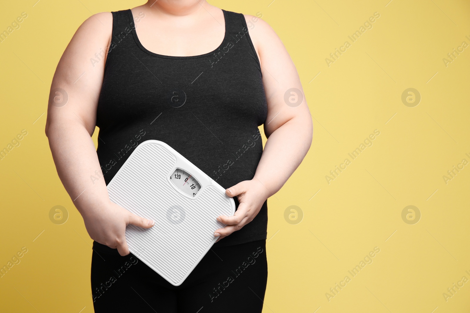 Photo of Overweight woman with scales on color background