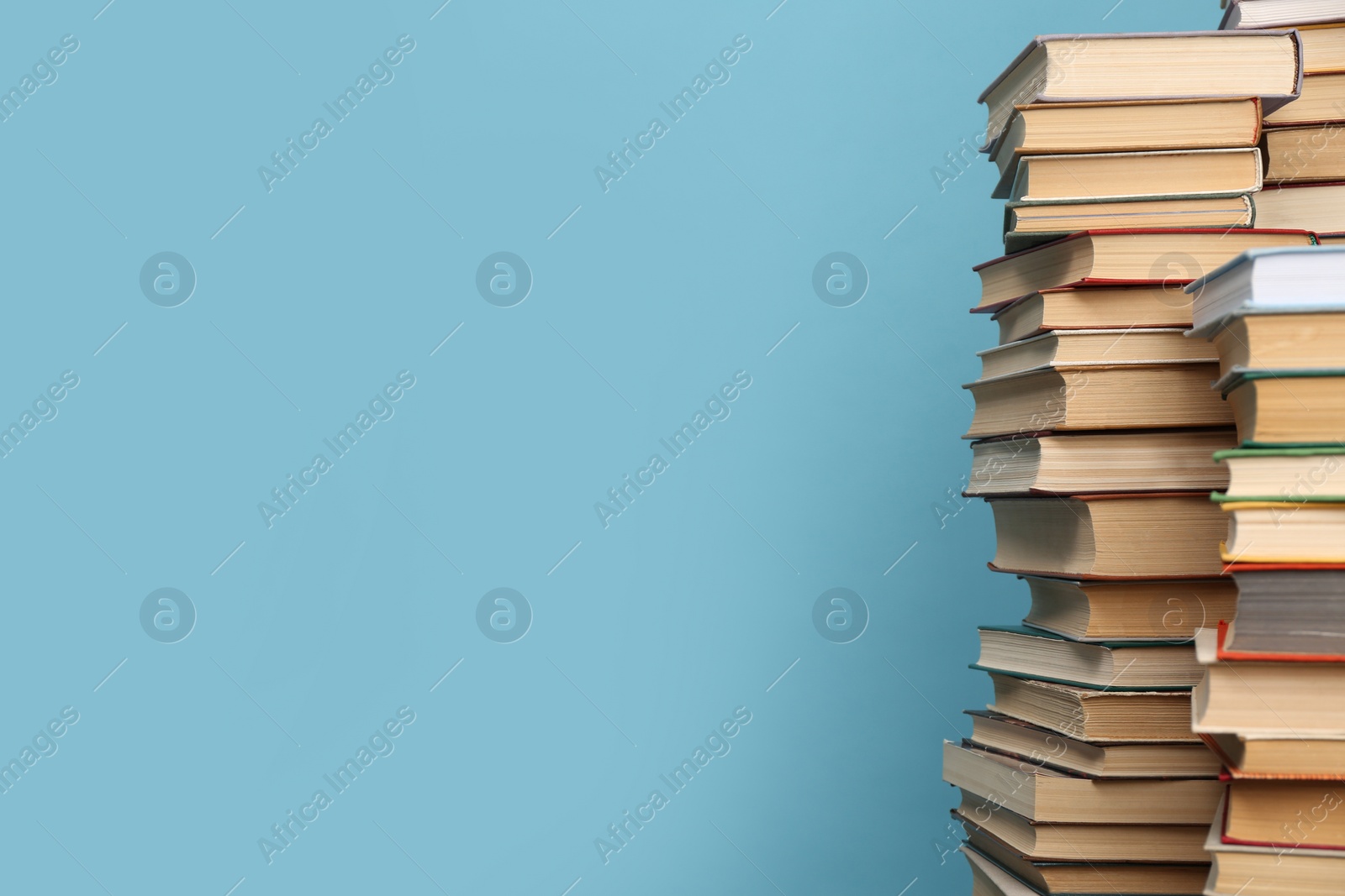 Photo of Many hardcover books on turquoise background, space for text. Library material