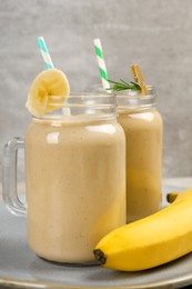 Photo of Tasty banana smoothie and fresh fruit on table