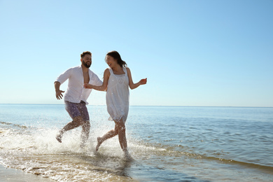 Photo of Happy young couple having fun at beach. Honeymoon trip