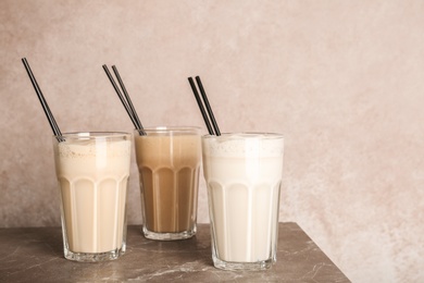 Photo of Glasses with delicious milk shakes on table