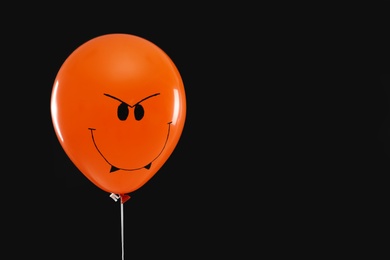 Photo of Spooky balloon for Halloween party on black background, space for text