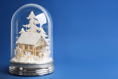 Photo of Beautiful snow globe on blue background, space for text