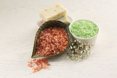 Aromatic sea salt and beautiful flowers on white wooden table