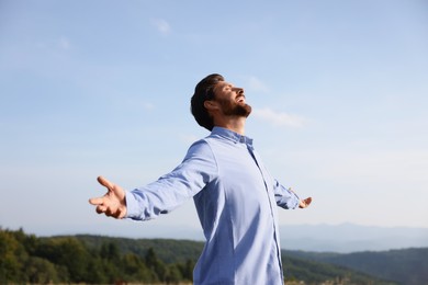 Photo of Feeling freedom. Happy man with wide open arms outdoors