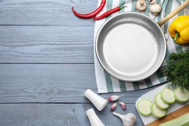 Photo of Flat lay composition with frying pan and fresh products on grey wooden table, space for text