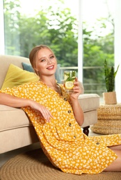 Young woman with glass of lemonade at home. Refreshing drink