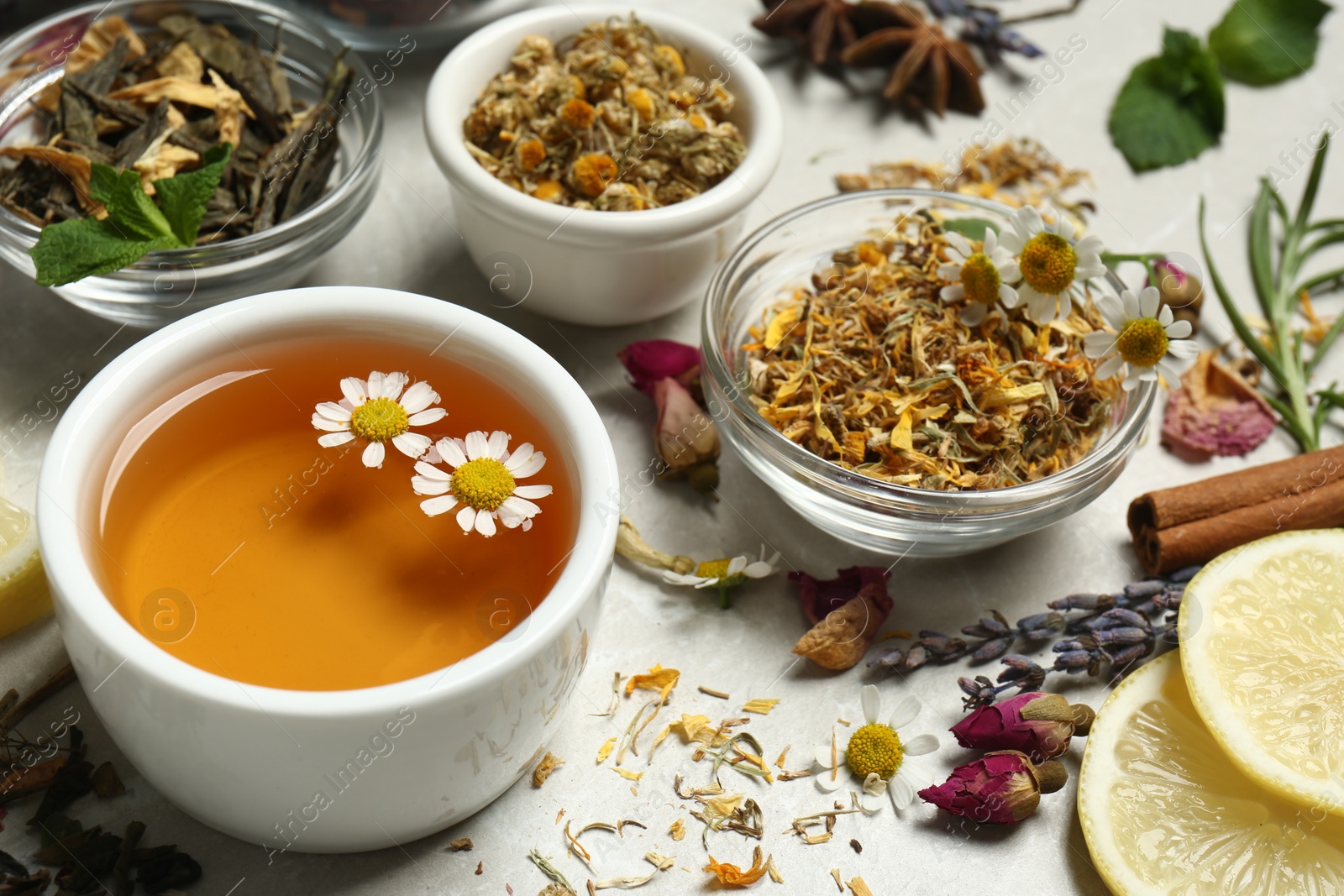 Photo of Fresh brewed tea and dry leaves on light table