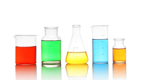 Photo of Different laboratory glassware with colorful liquids isolated on white
