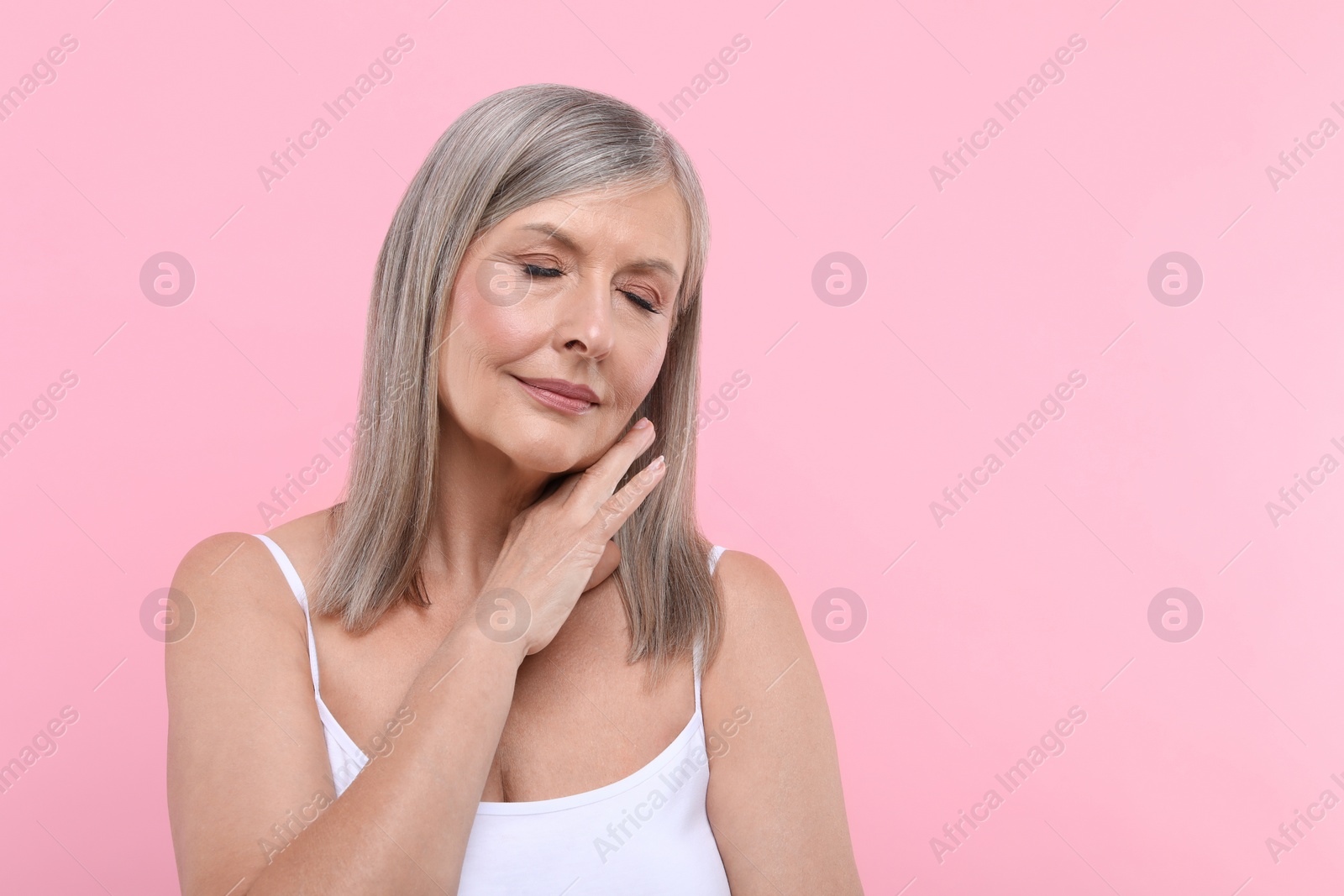 Photo of Portrait of beautiful senior woman on pink background. Space for text