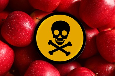 Image of Skull and crossbones sign on fresh apples, closeup. Be careful - toxic