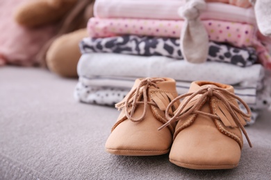 Photo of Child shoes and stack of clothes on background