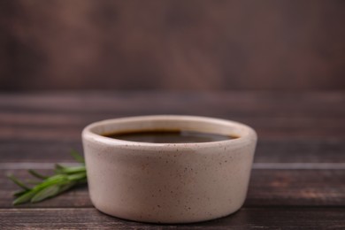 Bowl with balsamic vinegar on wooden table