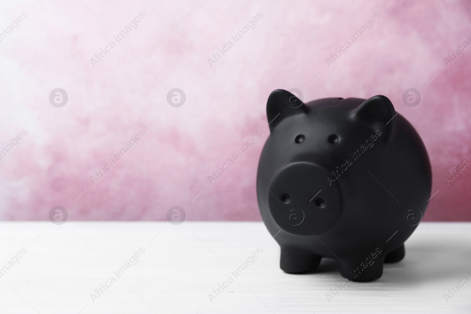 Photo of Black piggy bank on table. Money saving