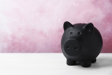 Photo of Black piggy bank on table. Money saving