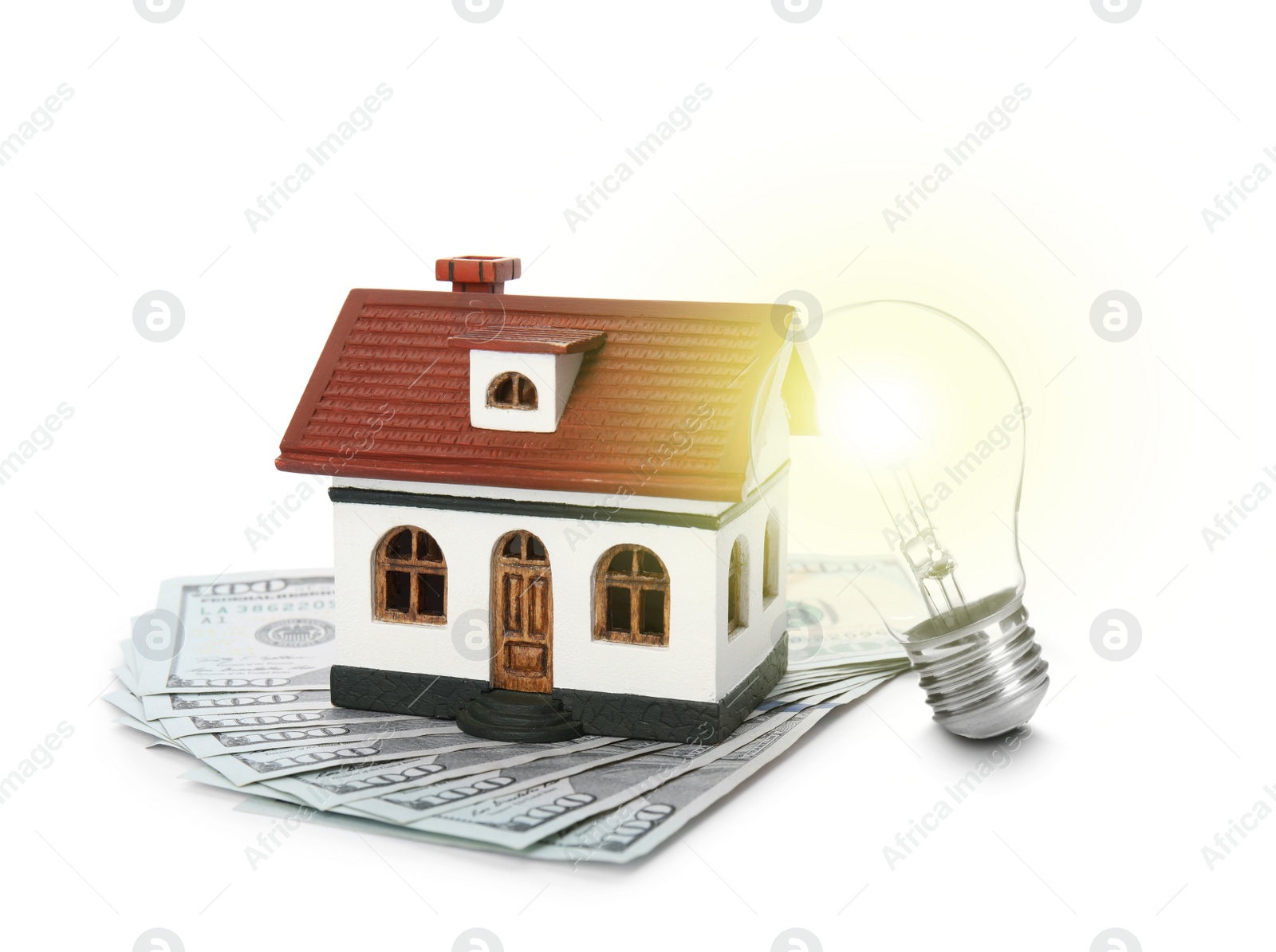 Image of Glowing light bulb, model of house and banknotes on white background. Energy efficiency, loan, property or business idea concepts