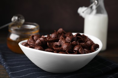 Photo of Breakfast cereal. Chocolate corn flakes in bowl on table, closeup