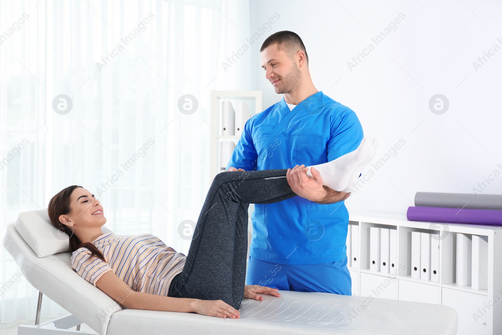 Photo of Doctor working with patient in hospital. Rehabilitation physiotherapy