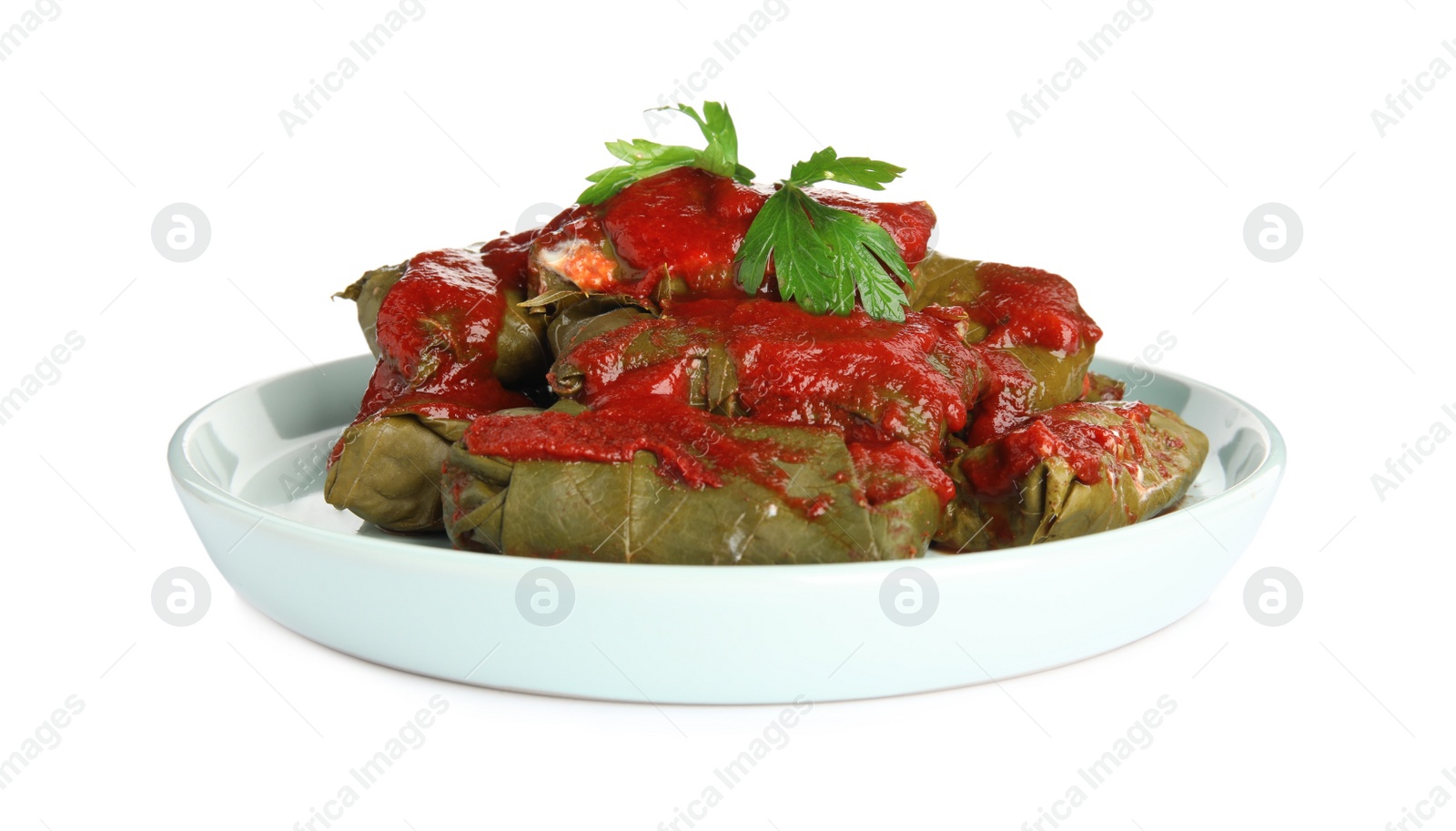 Photo of Plate of delicious stuffed grape leaves with tomato sauce and parsley isolated on white