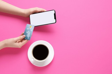 Online payment. Woman with smartphone, credit card and coffee on pink background, top view. Space for text