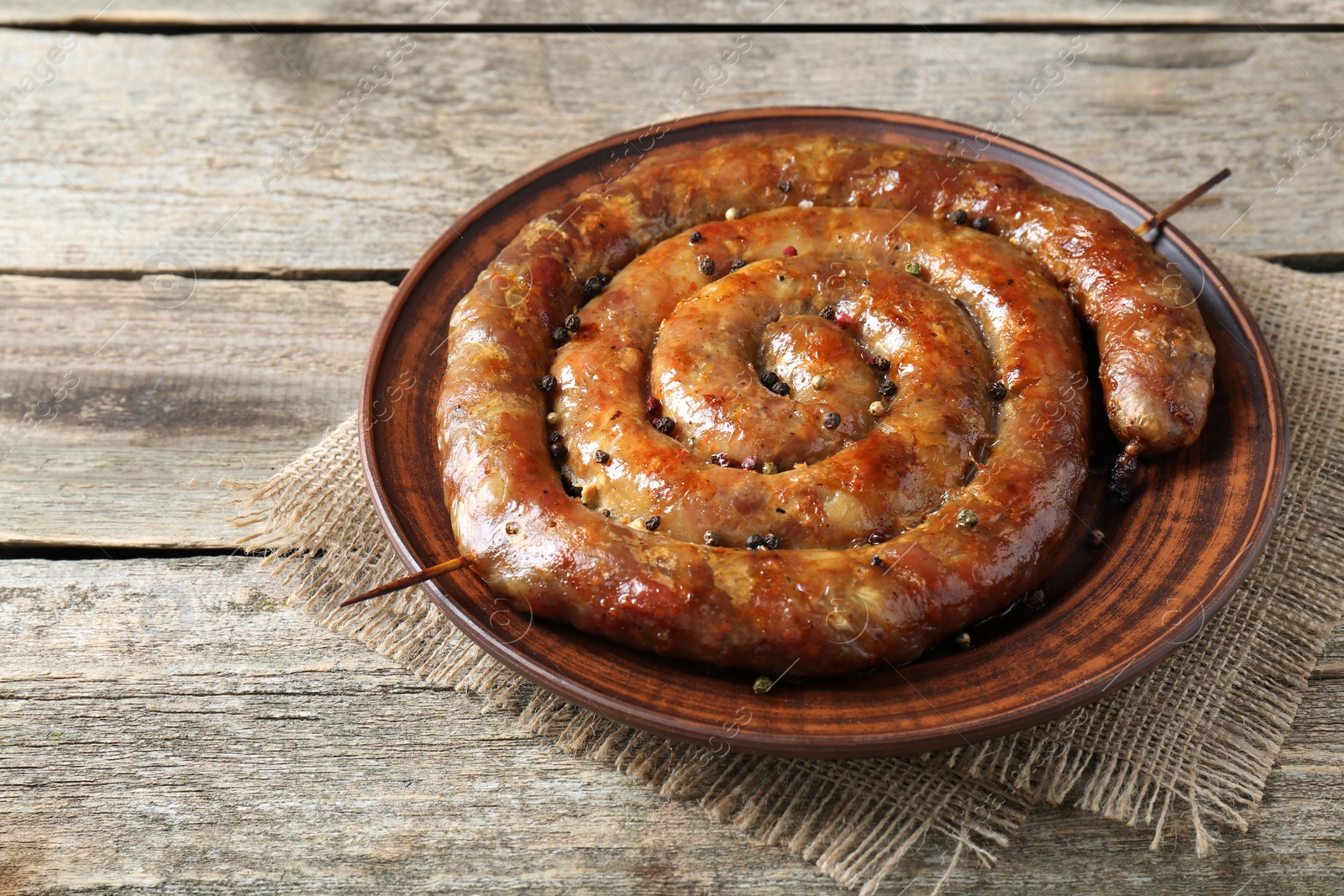 Photo of Plate with tasty homemade sausages on wooden table