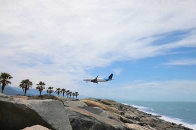 Photo of Modern white airplane landing on rocky seacoast