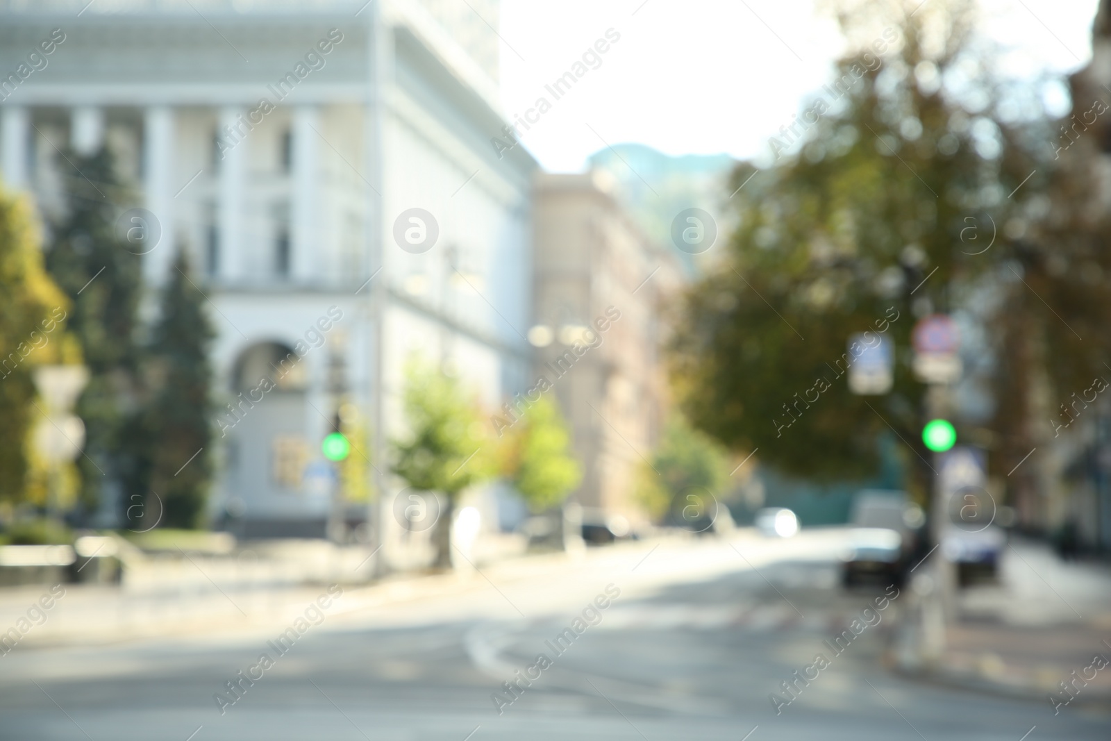 Photo of Blurred view of quiet city street empty road on sunny day