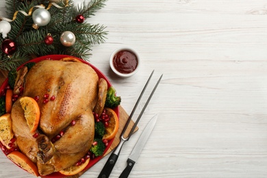 Photo of Delicious chicken with oranges, pomegranate and vegetables on white wooden table, flat lay. Space for text