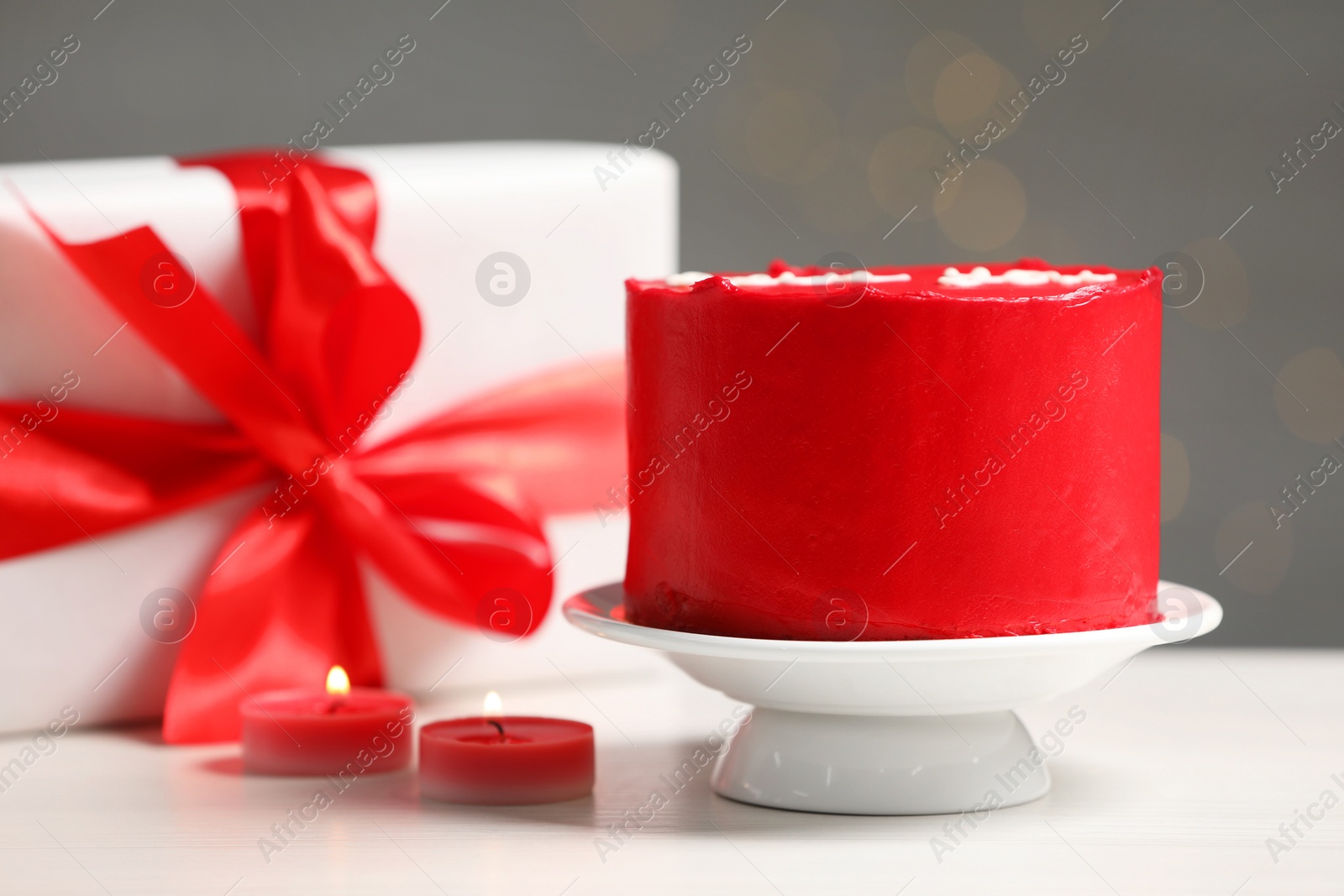 Photo of Bento cake, gift box and candles on white wooden table. St. Valentine's day surprise