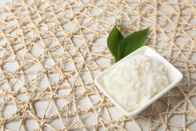 Shea butter in bowl on wicker mat. Space for text