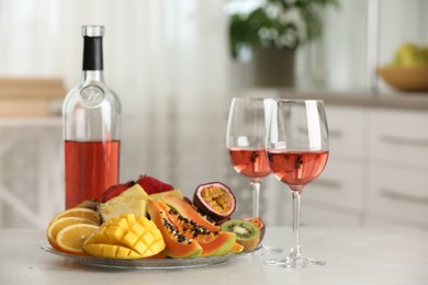 Photo of Delicious exotic fruits and wine on white table indoors