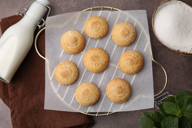 Photo of Tasty sweet sugar cookies, milk and mint on brown table, flat lay