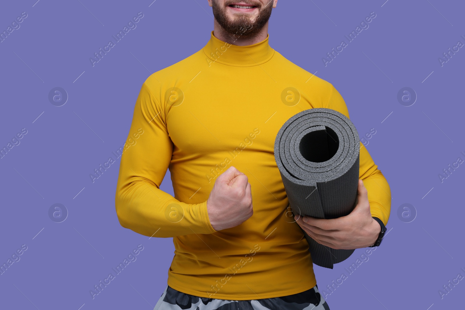 Photo of Man with fitness mat on purple background, closeup