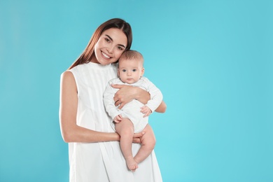 Portrait of happy mother with her baby on color background. Space for text