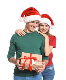 Young couple with Christmas gift on white background