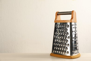 Modern grater on white wooden table. Space for text