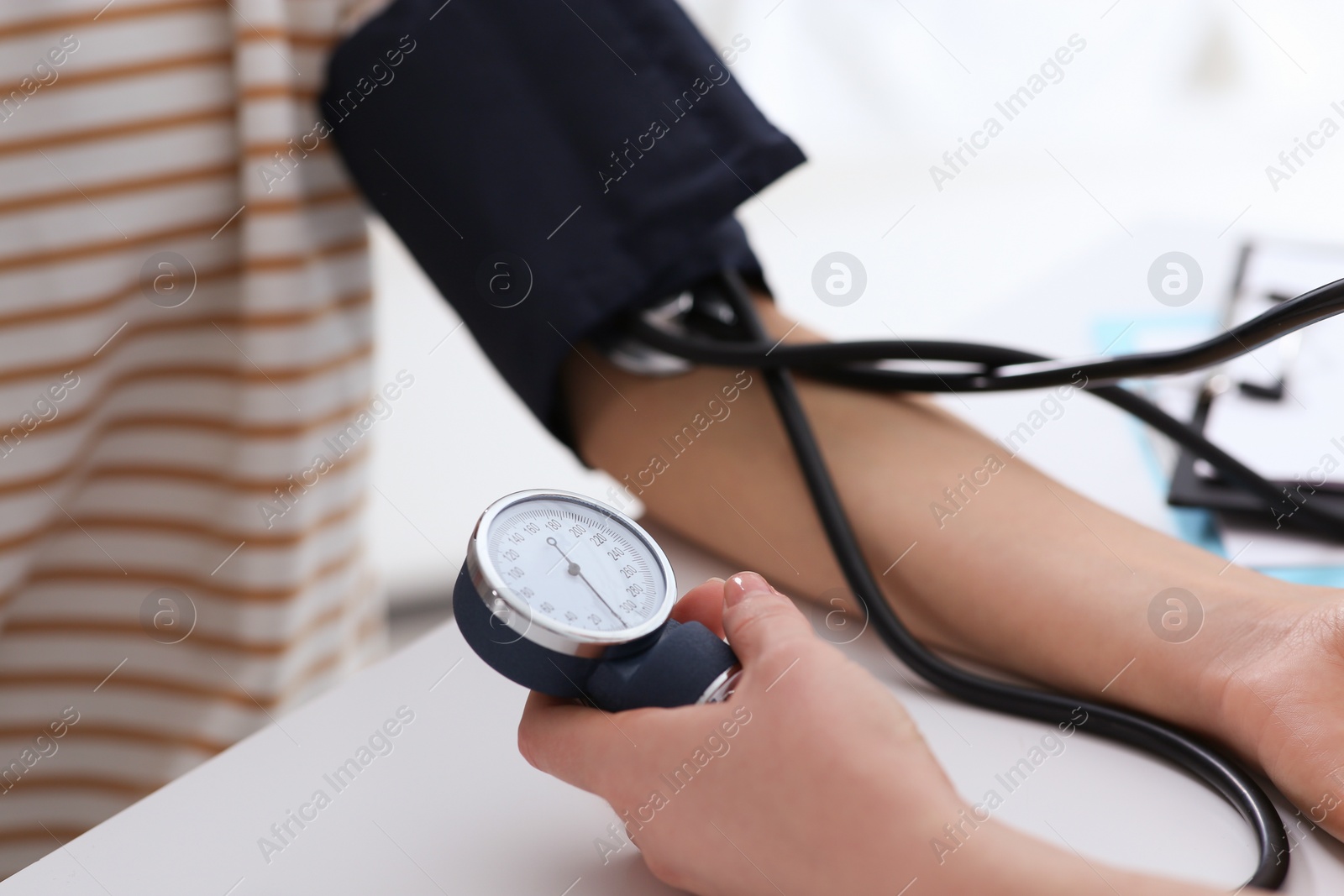 Photo of Doctor checking blood pressure of woman in clinic, closeup