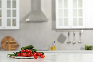 Fresh clean vegetables on white table in kitchen, space for text