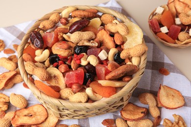 Mixed dried fruits and nuts on beige background, closeup