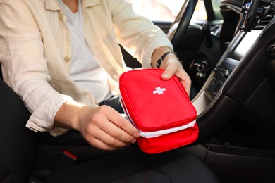 Photo of Man with first aid kit inside car, closeup