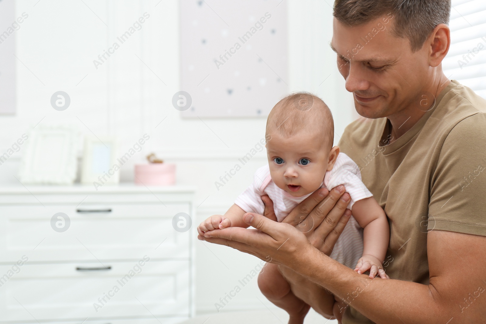 Photo of Happy father with his little baby at home. Space for text