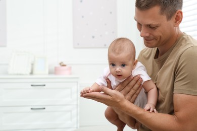 Photo of Happy father with his little baby at home. Space for text