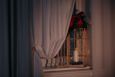 Beautiful Christmas lantern with candle on window sill indoors