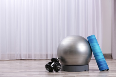 Photo of Set of fitness equipment on floor indoors. Space for text